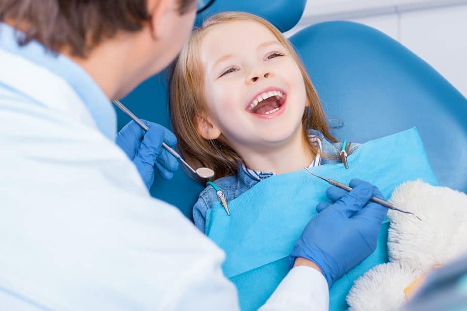 a child smiles in a dental chair