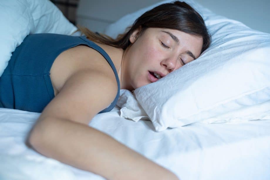 a woman snores in bed